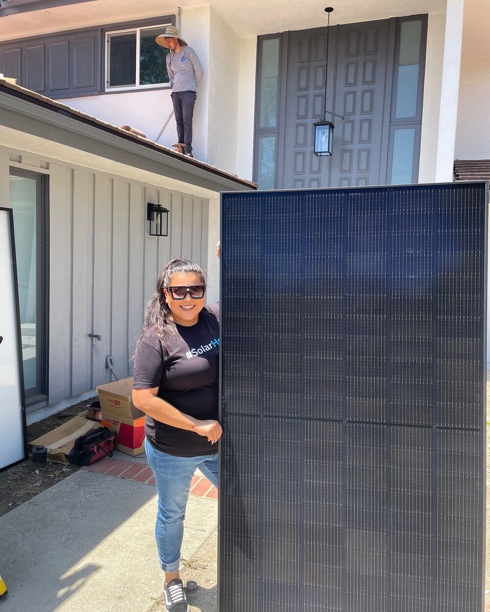 Rebecca Jones with a solar panel at a home installation